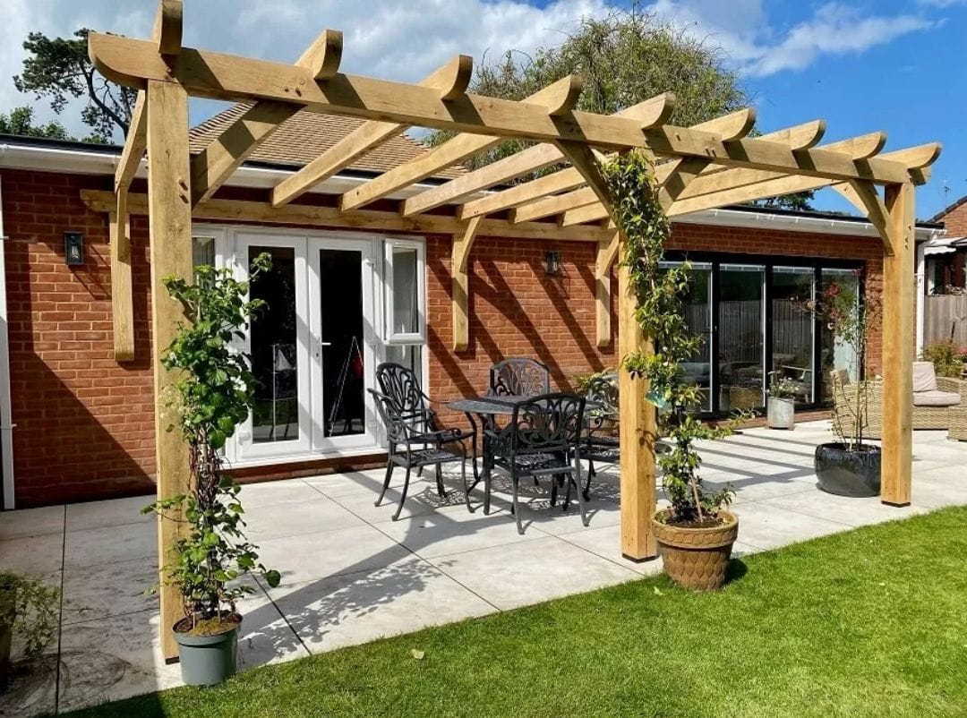 a wooden pergola attached to house with climber plant - grandseabuilding.com